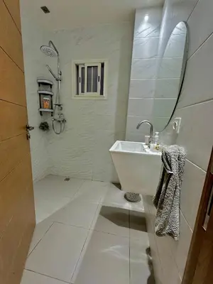 a white bathroom with a sink and a mirror at Cozy appartement Rabat Wifak 5min de Harhoura beach in Temara