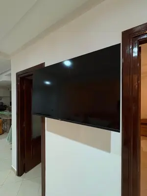 a large flat screen tv hanging on a wall at Harhoura stay à 10min du stade Prince Moulay Abdellah ! in Temara
