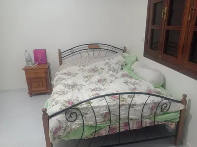 a bedroom with a bed with a floral comforter at 2 bedroom apartment and living room with small terrace in Skhirat
