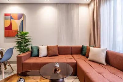 a living room with a brown couch and a table at Self Check In 1BR With Gym And Coworking Near CFC in Casablanca