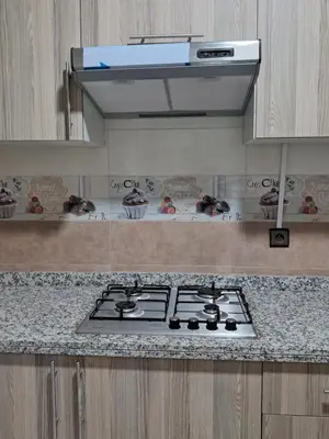 a stove top in a kitchen with a hood at Baya Residentie in Temara