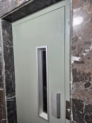 a bathroom door with a mirror and a stone wall at Baya Residentie in Temara