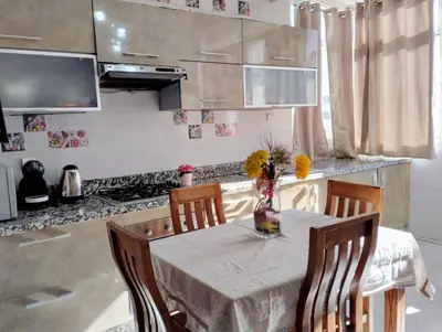 a kitchen with a table with a vase of flowers on it at Camera a 2 minuti dal mare e la mosquee Hassan 2 in Casablanca-Port