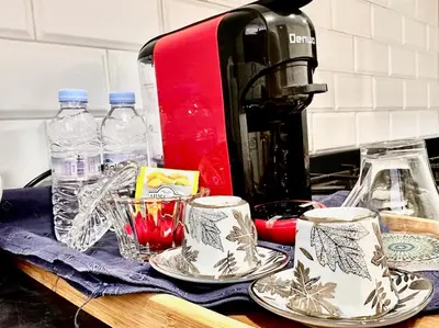 a table with plates and a coffee maker and bottles of water at Elegant apartment in Nouaceur, Close to Airport in Nouaseur