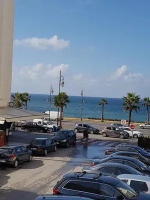a parking lot with cars parked next to the ocean at Sea view Apart Rabat in Rabat