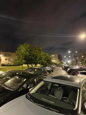 a parking lot filled with parked cars at night at Appartement idéal pour la CAN à 5 min du stade Moulay Abdellah in Rabat