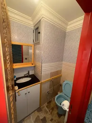 a bathroom with a blue toilet and a sink at Appartement idéal pour la CAN à 5 min du stade Moulay Abdellah in Rabat