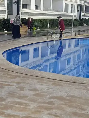 a group of people cleaning a swimming pool at Appt Mansbay beach in Mansouria