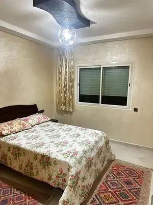 a bedroom with a bed and a chandelier at Appartement central à Témara, trés proche de Rabat Av Tarik Ibn Zaid in Temara
