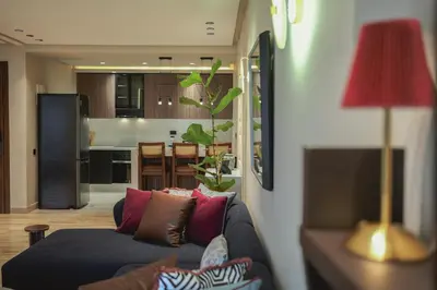 a living room with a couch and a kitchen at Marhaba Experience Appartement Luxe Belvedere in Casablanca