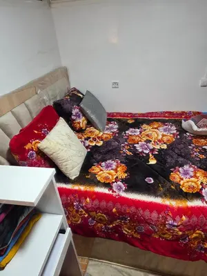 a bed with a colorful blanket and pillows on it at Appartement meublée à RABAT for CAN 2025 in Temara