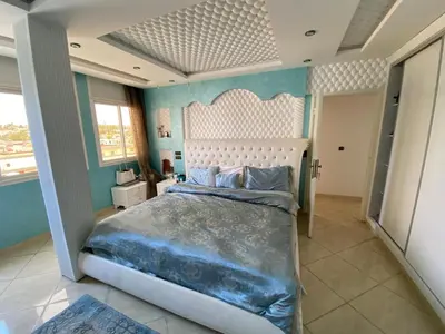 a bedroom with a large bed with blue walls at Appartement prestigieuse en plein cœur de Hay Riad et près du stade Moulay Abdallah in Rabat