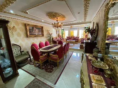 a living room with a table and red chairs at Appartement prestigieuse en plein cœur de Hay Riad et près du stade Moulay Abdallah in Rabat