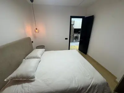 a bedroom with a white bed with a window at Modern Cozy Studio with Open-Plan Kitchen near All Amenities Rabat in Rabat