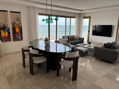 a living room with a dining table and a living room with the ocean at Carrousel Atlantic View in Rabat