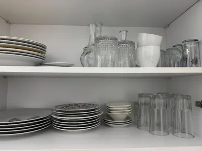 a white shelf with plates and bowls and glasses at Premium comfort, 150m from Val d'Or beach, 2 swimming pools in Temara