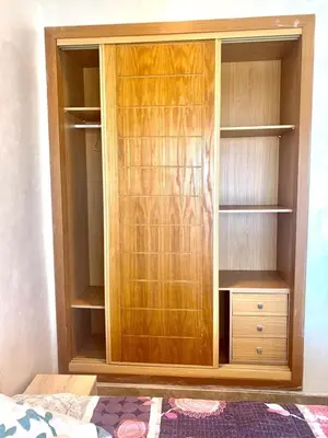a wooden closet with wooden shelves in a bedroom at Appartement en bord de Mer in Mohammedia