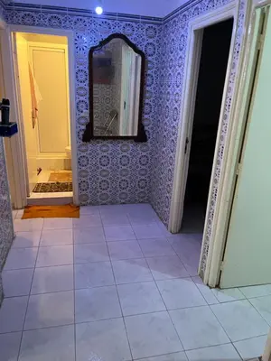 a hallway with purple walls and a mirror and a tile floor at Location des appartements souf in Temara