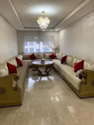 a living room with a large couch and a table at Apartment in a residence with pool in Mohammedia