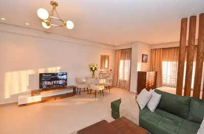 a living room with a green couch and a table at Studio 01 Maarif - High Speed Wi-Fi in Casablanca