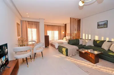 a living room with a green couch and a bed at Studio 01 Maarif - High Speed Wi-Fi in Casablanca