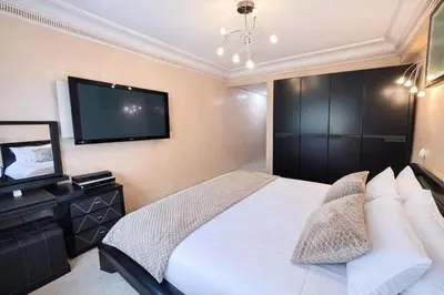 a bedroom with a bed and a flat screen tv at Grand 3 pièces de standing, confort premium in Casablanca