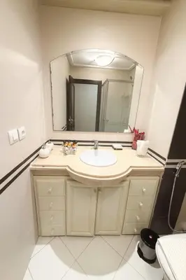a bathroom with a sink and a large mirror at Grand 3 pièces de standing, confort premium in Casablanca