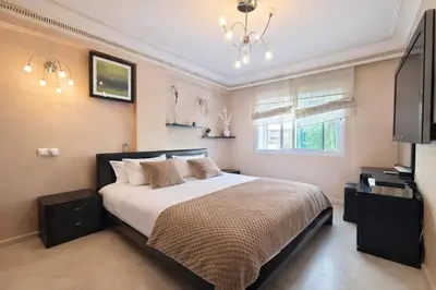 a bedroom with a large bed and a television at Grand 3 pièces de standing, confort premium in Casablanca