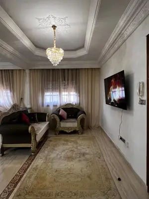 a living room with two chairs and a chandelier at Appartement confortable à Rabat, idéalement situé près de la Corniche et du Stade in Rabat