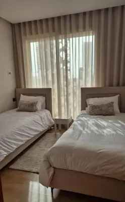 a bedroom with two beds and a large window at Appartement CFC - Anfasky in Casablanca