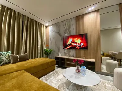 a living room with a couch and a tv on a wall at Beau Living Park Residence Bright Central Cosy Apartment Beauséjour Centre De Casablanca En Face De Anfa Park in Casablanca