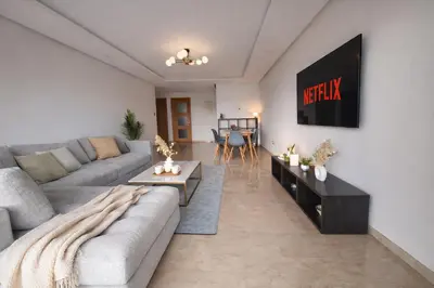 a living room with a couch and a tv at Central Modern Apartment Agdal TGV Train Station in Rabat