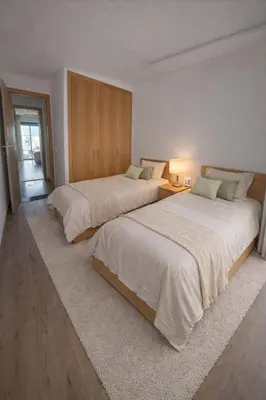 two beds in a white room with at Central Modern Apartment Agdal TGV Train Station in Rabat