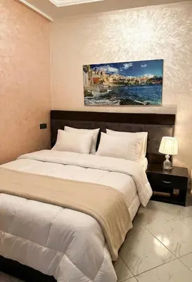 a bedroom with a large bed and a painting on the wall at Séjour économique près de la plage in Bouznika