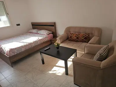 a bedroom with a bed and a couch and a table at Superbe studio a avenue france agdal in Rabat
