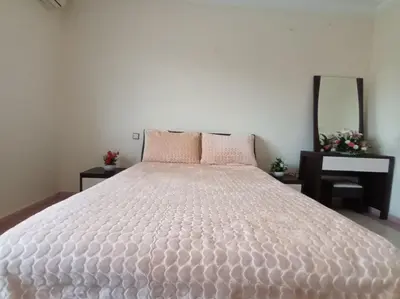 a large white bed in a bedroom with a mirror at Villa stade Moulay Abdellah in Temara