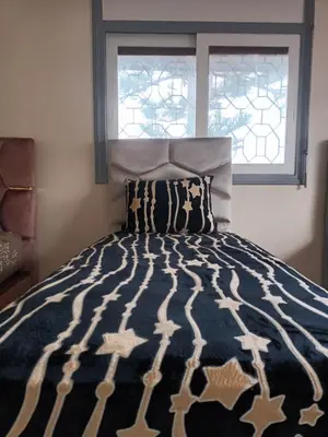 a bedroom with a large bed with a window at Villa stade Moulay Abdellah in Temara