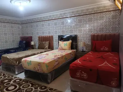 a bedroom with two beds and a couch in it at Villa stade Moulay Abdellah in Temara