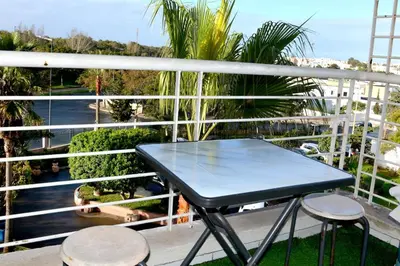 a blue table and two stools on a balcony at Appartement familial convivial in Rabat