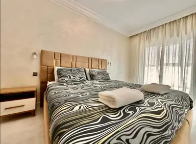 a bedroom with a large bed with a black and white comforter at Rome Avenue Luxury Residence, 3 Chambres in Casablanca