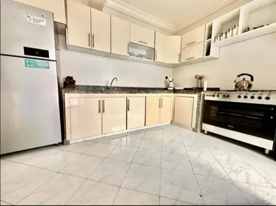 a large kitchen with white cabinets and a refrigerator at Rome Avenue Luxury Residence, 3 Chambres in Casablanca