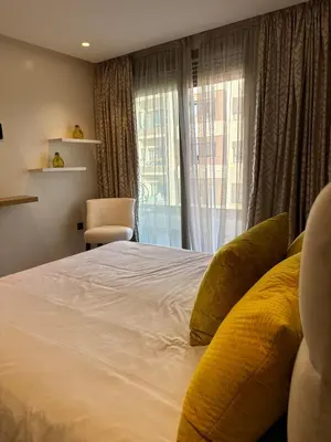 a bedroom with a large white bed with a window at Séjour Premium Casablanca in LʼOasis