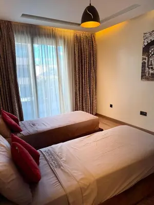two beds in a hotel room with a window at Séjour Premium Casablanca in LʼOasis