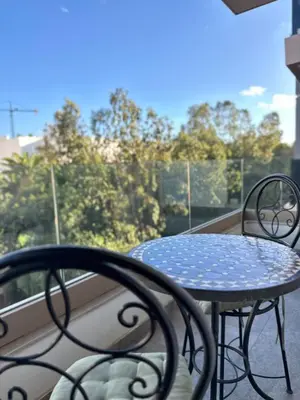 a table and chairs on a balcony with a view at Séjour Premium Casablanca in LʼOasis