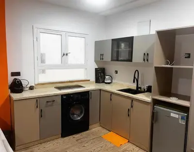 a kitchen with a washing machine and a window at Olive & Orange Modern Studio in Rabat