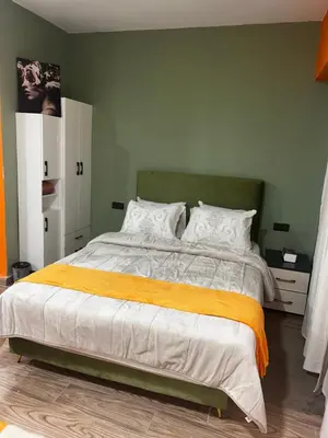 a bedroom with a large bed with an orange blanket at Olive & Orange Modern Studio in Rabat