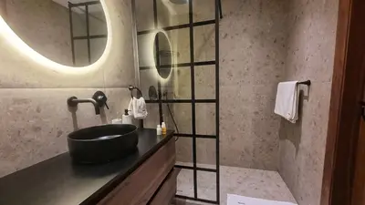 a bathroom with a black sink and a mirror at Suite Cozy Design Suite Maarif, Close to Ain Diab in Casablanca