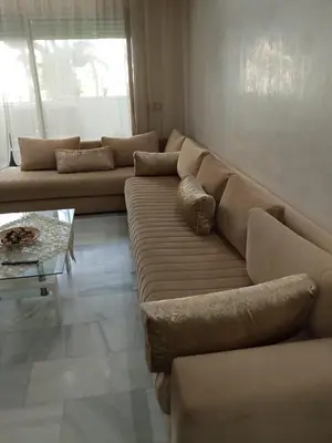 a living room with a large couch and a table at La Siesta Beach Appartement in Mohammedia