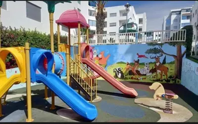 a childrens playground with a slide and a slideintend at La Siesta Beach Appartement in Mohammedia
