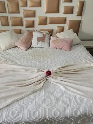 a large white bed with pink and white pillows at La Siesta Beach Appartement in Mohammedia